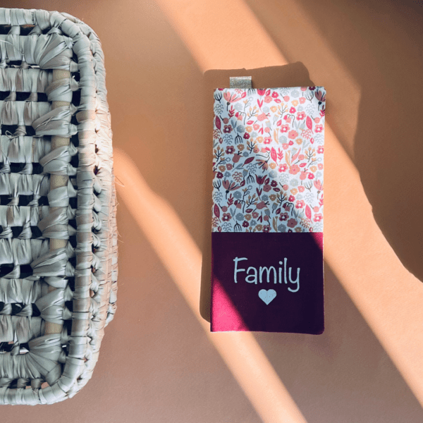 protège livret de famille avec un tissu à fleurs dans les tons marsala et un tissu uni bordeaux sur lequel est écrit family avec un coeur