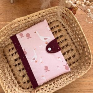 protège carnet de santé molletonnée avec un tissu rose avec des oies blanches