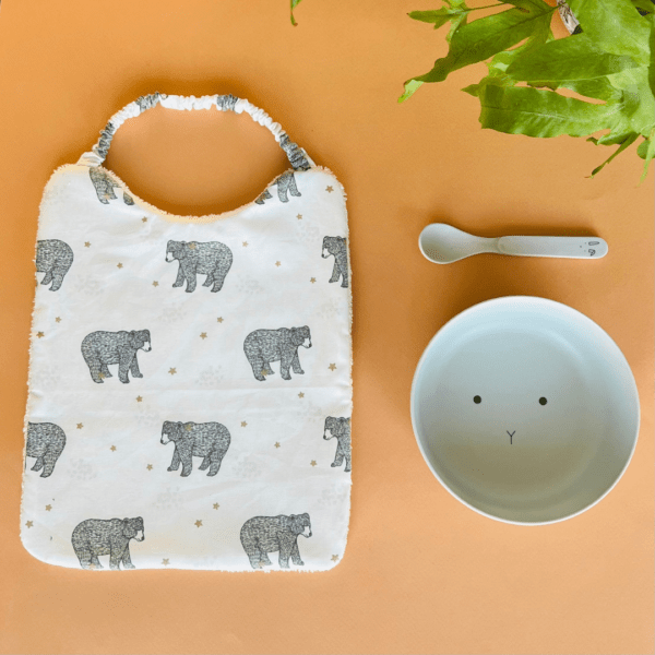 bavoir élastique avec un tissu ours sur fond blanc et une éponge blanche au verso