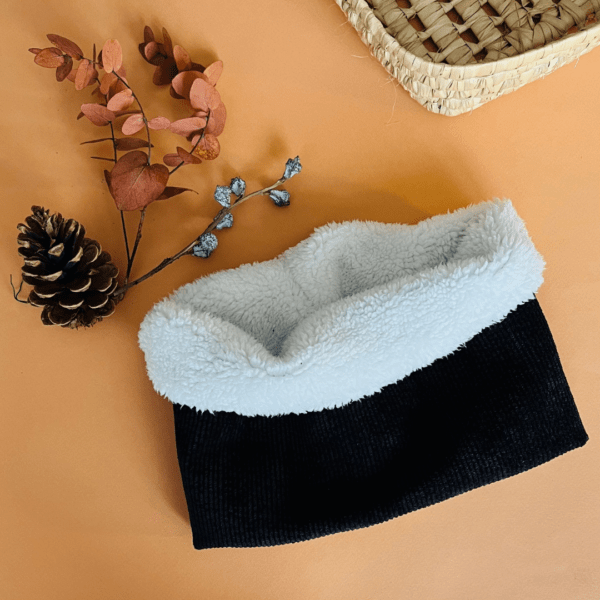 tour de cou chaud avec un tissu extérieur en velours côtelé noir et un tissu intérieur en sherpa couleur ivoire