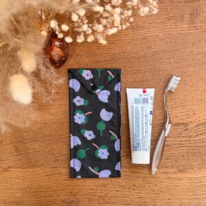 étui à brosse à dents couleur noire avec des fleurs verte et violette