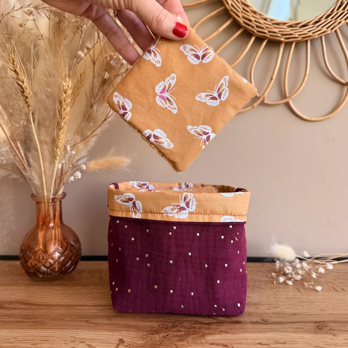 panière à lingettes en double gaze à pois dorés couleur bordeaux avec lingettes couleur camel avec des papillons et éponge de bambou camel
