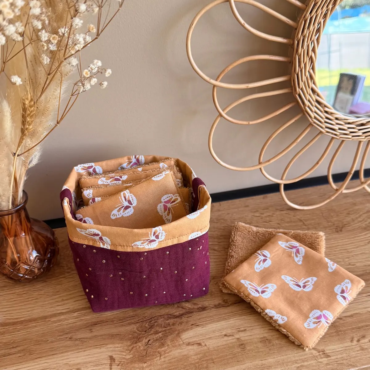 panière à lingettes en double gaze à pois dorés couleur bordeaux avec lingettes couleur camel avec des papillons et éponge de bambou camel