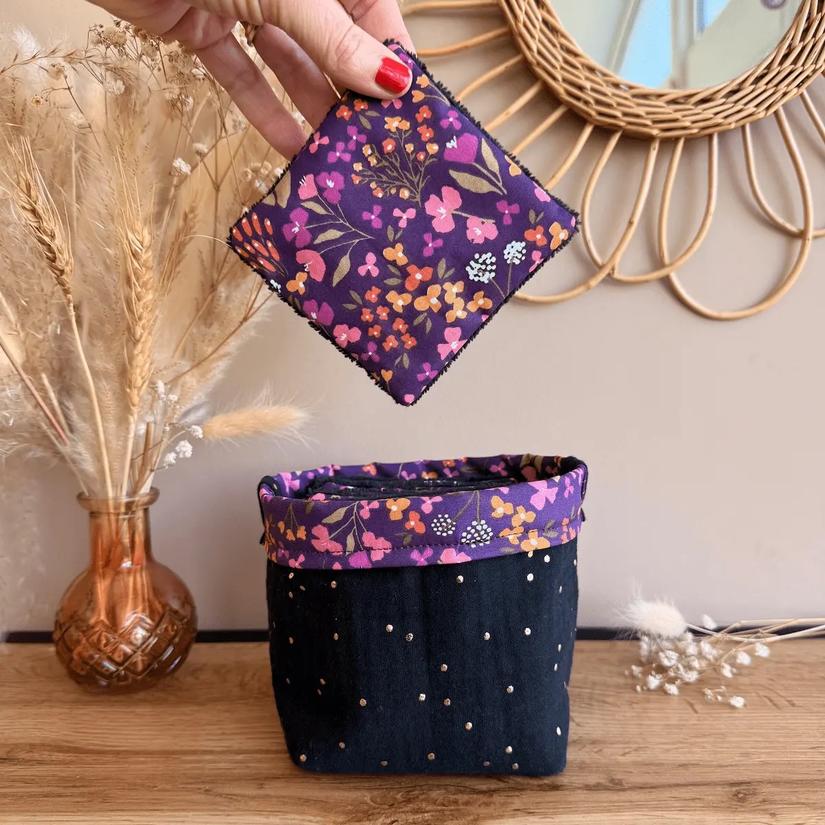 panière en double gaze à pois dorés noir avec des lingettes couleur violette avec des petites fleurs et de l'éponge de bambou noire