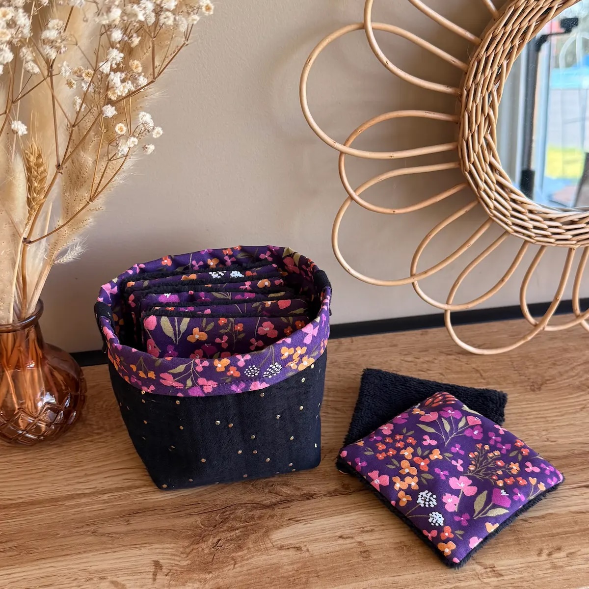 panière en double gaze à pois dorés noir avec des lingettes couleur violette avec des petites fleurs et de l'éponge de bambou noire