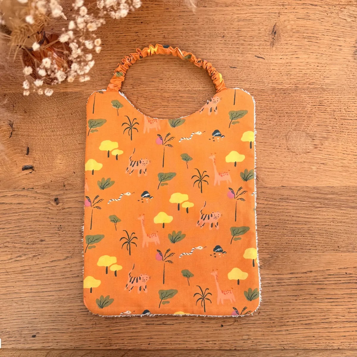 bavoir élastique en éponge et tissu orange avec des girafes