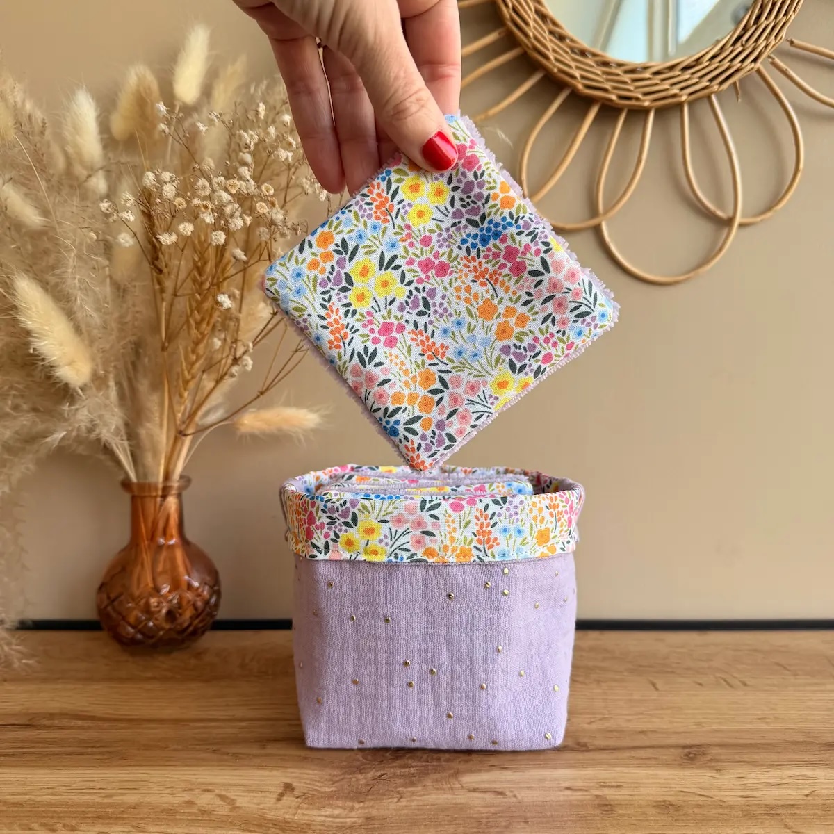 panière en double gaze à pois dorés couleur lilas avec lingettes en coton blanc avec des fleurs multicouleurs