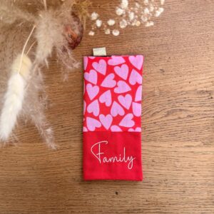protège livret de famille en tissu rouge avec des coeurs rose et une broderie family couleur blanche